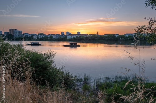Coucher de soleil coloré sur la Loire et la skyline de Nantes, vue paisible depuis les rives de Saint-Sébastien-sur-Loire