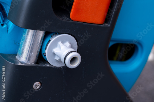 Fotografie Close-up of a plastic quick-connect adapter for a garden hose on a hose reel