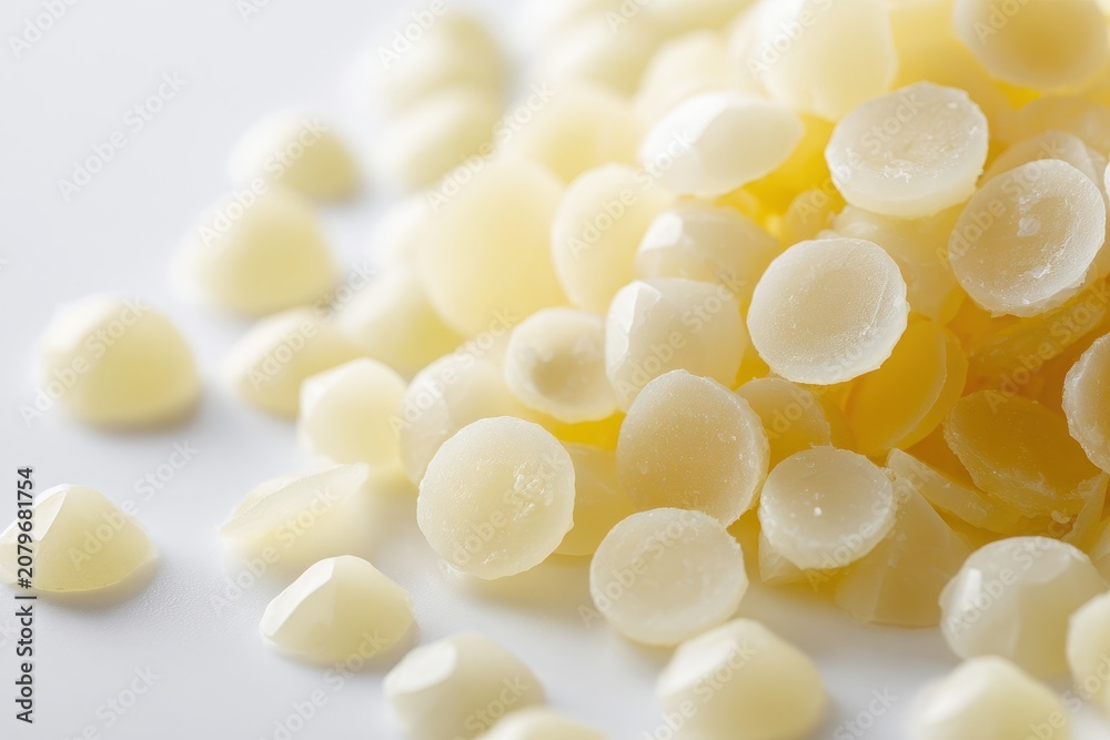 Fototapeta premium Texture-rich macro shot of cosmetic wax beads on a smooth white surface