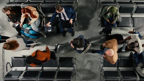 Bild auf Leinwand Boarding flight, departing airplane and tourists in airport lounge standing up from chairs with boarding gate