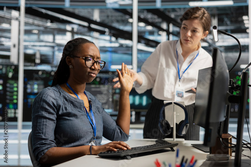 Foto Data center worker makes a dismissive gesture during a workplace conflict over performance issues in a server room