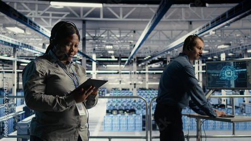 Photography African American system administrator uses AI on a tablet in a server farm to help customers resolve website hosting problems