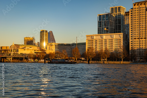 Riverside City Skyline at Golden Hour With Modern Buildings and River Reflections in London UK