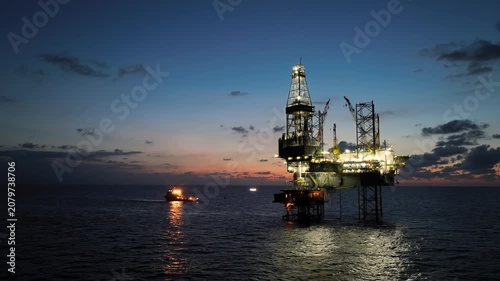 aerial, offshore, jack-up, rig, platform, oil, gas, exploration, production, energy, sunset, twilight, dusk, industrial, maritime, ocean, sea, horizon, sky, orange, derrick, crane, legs, lattice, stee