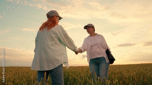 Foto Businesswomen shaking hands in field