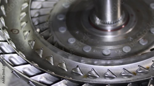 Close up detailed view of the curved metallic fins and blades inside an automotive automatic transmission torque converter component.