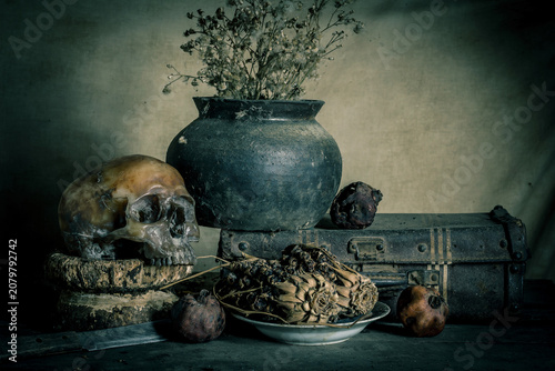Human skull and flower vase old treasure on wooden table background, Still life concept