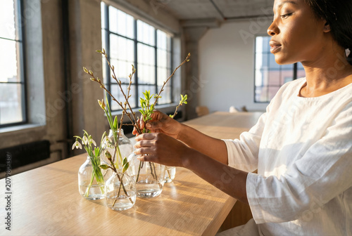 Woman arranging spring branches in glass vases