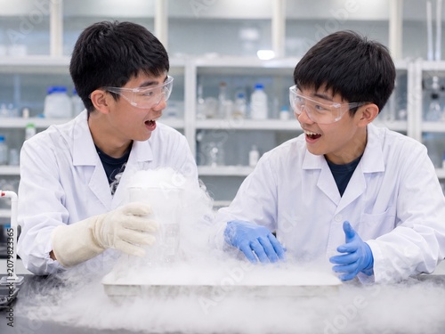 Two Young Students Conducting Science Experiment with Dry Ice in Laboratory