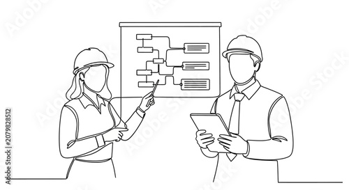Engineers discussing project plans on whiteboard.