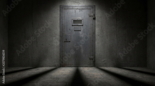 Heavy solid steel door of a solitary confinement prison cell featuring a closed view slot