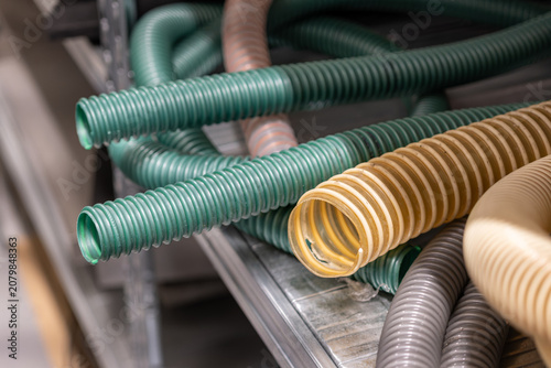 Sections of hoses with reinforced plastic rim on a shelf in a warehouse.