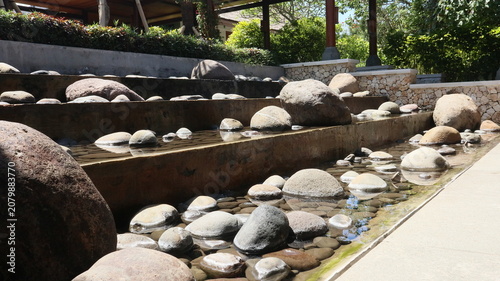 Konstfotografi open garden design behind the house using real river stones and a gurgling water