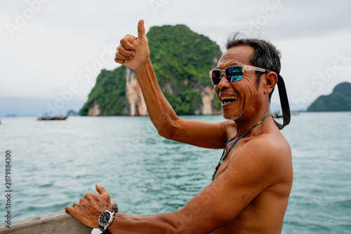 Fotografía Thai boatman smiling, giving thumbs up, enjoying ocean travel