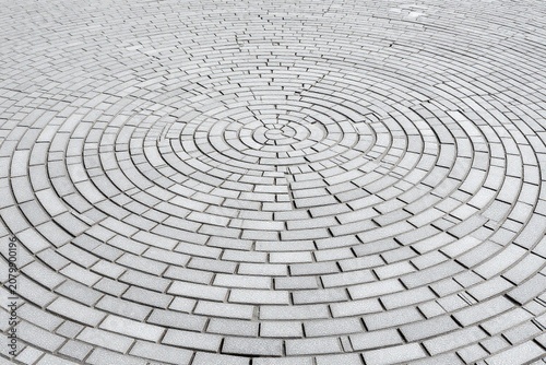 A circular brick walkway in the middle of a park