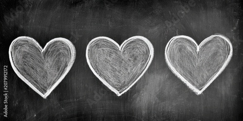 Three chalk-drawn hearts on a blackboard