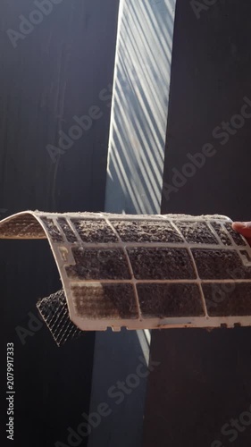Closeup cropped shot of unrecognizable man examining holding dusty air conditioner filter in hands before cleaning at home. Concept for maintenance of hygiene and pure air to prevent allergies.