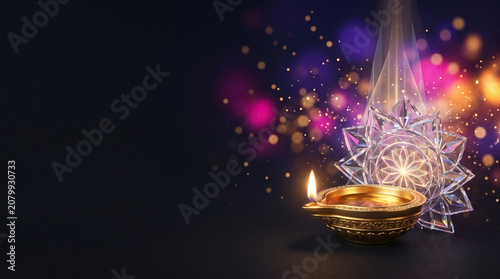 Traditional golden diya lamp with decorative crystal mandala on a dark bokeh background