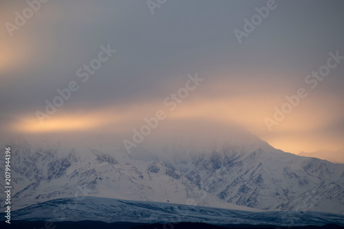 Fog over mountain at sunset in Alaska.