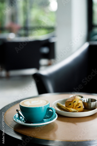 Cup of hot latte coffee on table by the window.