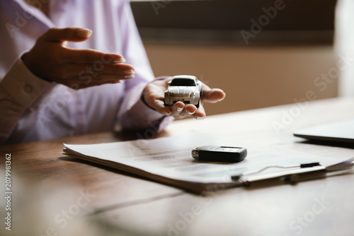 Foto Hands protecting a model car, symbolizing vehicle insurance, financial protection, ownership, and automotive security