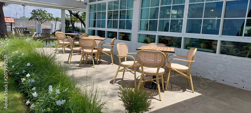 set of rattan furniture is situated under the translucent roof out side the restaurant