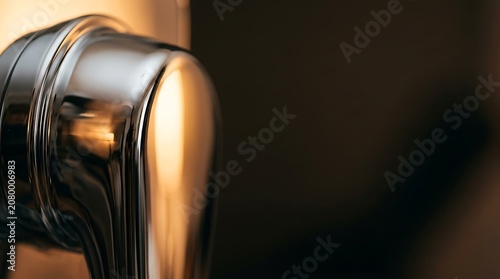 Polished metallic surface with golden light reflections macro