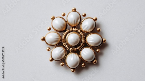 Elegant vintage floral brooch featuring white pearls and intricate gold detailing on a plain background