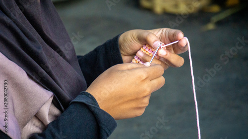 Creating items (lipstick holder) using the craft of knitting. An activity in leisure time.