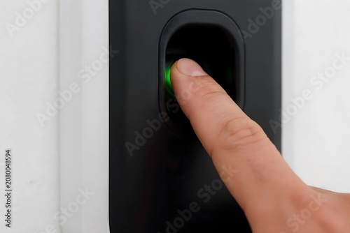 Person Activating Green Light on Black Device with Finger Technology Control Concept