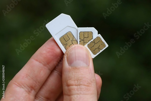 Hand Holding Three SIM Cards Outdoors in Natural Environment Mobile Communication Concept