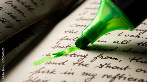 Close up of green highlighter marking text in an old book