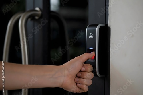 Woman Using Biometric Fingerprint Scanner on Smart Door Handle for Secure Access Control