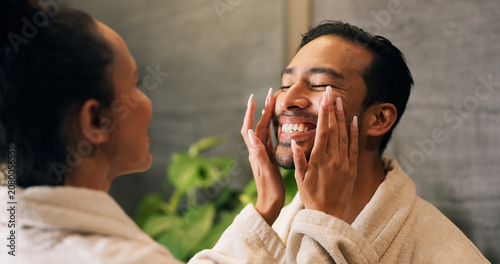 Foto Couple, skincare and face cream application in bathroom with smile, dermatology or hydration benefits