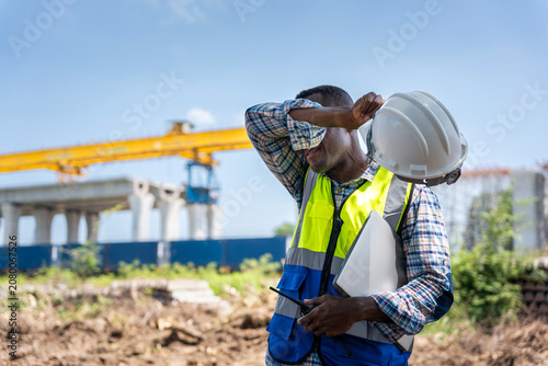Bild auf Leinwand Construction worker man wiping sweat under the hot sun, Exhausted engineer takin