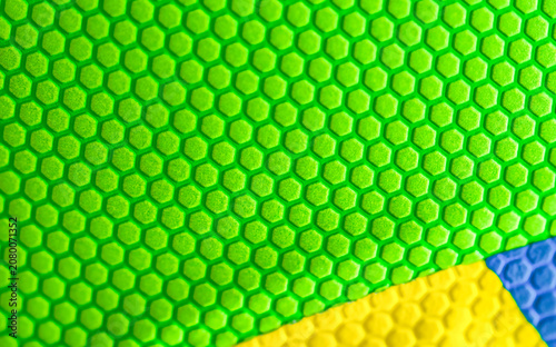 Bright green plastic textured background with yellow and blue elements