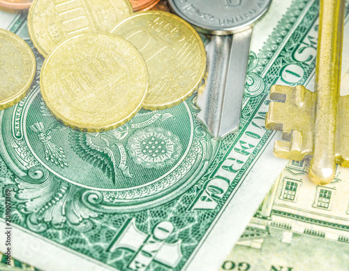 Close-up of green American paper dollar bills with golden coins stacked on them