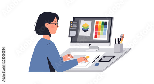 A young female graphic designer working on a creative project at her computer workstation.