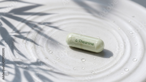 L-Theanine capsule on a round plate with water droplets under soft sunlight and plant shadows in a quiet indoor space