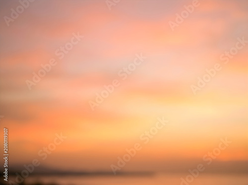 Sunset over calm ocean water with soft pink and orange sky at dusk