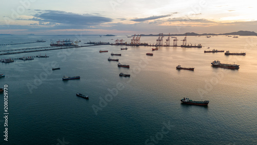 massive fleet heavy oil tankers and LNG vessels anchored at a strategic maritime chokepoint during a golden sunset, emphasizing global energy crises and petroleum supply chain infrastructure.