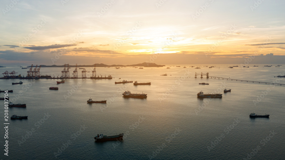 Obraz premium massive fleet heavy oil tankers and LNG vessels anchored at a strategic maritime chokepoint during a golden sunset, emphasizing global energy crises and petroleum supply chain infrastructure.