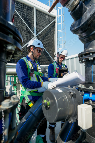 HVAC Engineers Inspecting Rooftop Cooling Tower. Industrial Maintenance Operation.