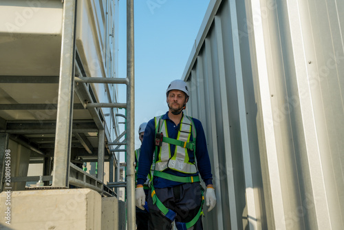 HVAC Engineer Ascending Cooling Tower Ladder. Rooftop Maintenance Work. Professional Industrial Inspection.