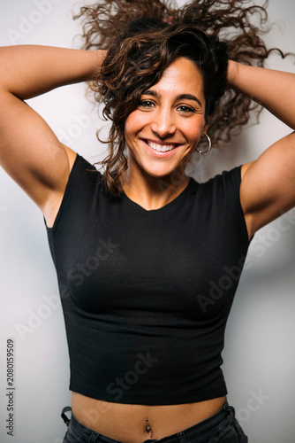 Happy woman smiling holding curly hair embracing confidence