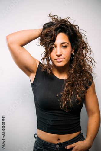 Confident young woman posing with curly hair