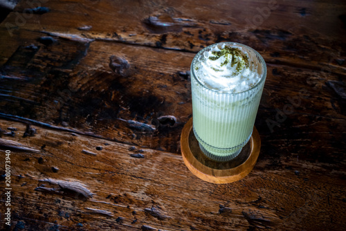 A glass of  Matcha Green Tea Milkshake topped and garnished with a cookie, and  white pasta.