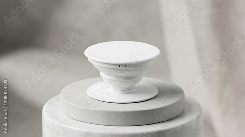 Isolated white smartphone expanding grip holder on textured pedestal phone accessory for better handling and ergonomic support
