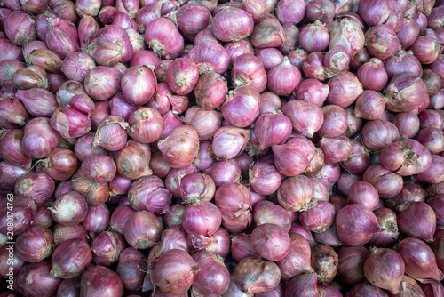 A pile of fresh red onion (Allium cepa) with dry skin on traditional market in Indonesia