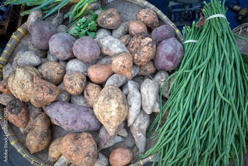 A pile sweet potatoes, Ipomoea batata, and long beans or snake beans (Vigna unguiculata subsp. sesquipedalis) on supermarket